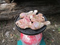 Выдержанные в маринаде куриные окорочка выкладываются на хорошо прогретую гриль-пластину